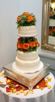 A three-tiered wedding cake with fondant frosting and flowers.