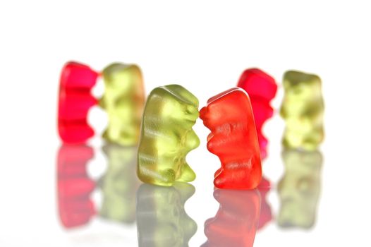 sweet gummy bears dancing on a party on white background