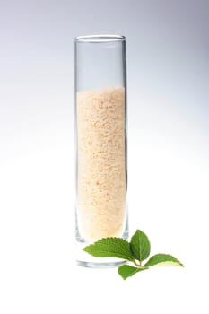 Rice grains in a high glass glass with a mint leaf.