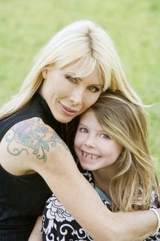 Pretty mom hugs her cute freckle-faced daughter