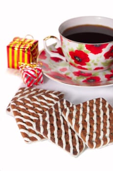 chocolate cookie with white cream and gift near by cup of coffe on white background