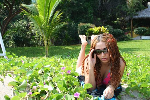 Portrait of woman on beach with plants and grass