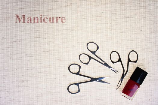 The special tool for care of nails with a small bottle red a varnish against from a fabric.