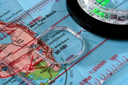 USA map with the city of Miami and a compass with magnifying glass over Miami.