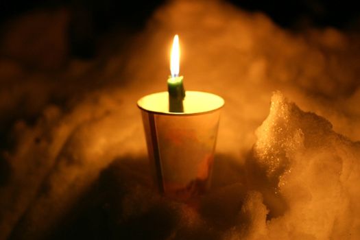 Memorial candle in cup stuck into snowbank