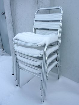 Pile of chairs covered by snow by winter