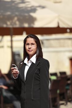 Businesswoman checking her mobile phone in a city.