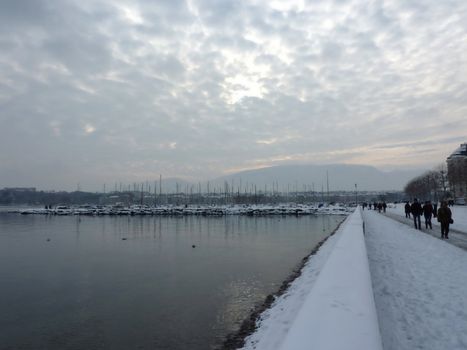 Snowy view of Geneva lake and harbor by winter