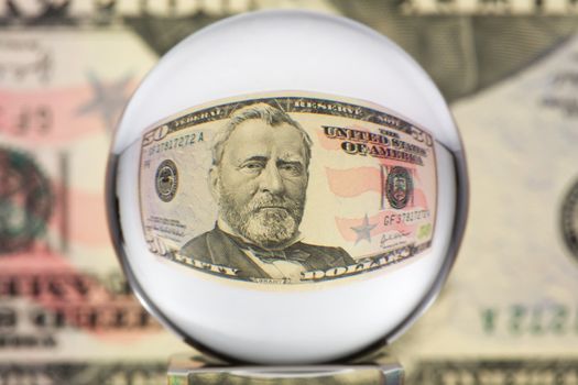 Fifty dollar banknote through glass sphere. Blur background.