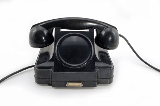 Old-fashioned black telephone receiver with cord on white background.