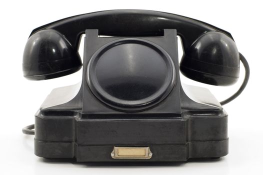 The old telephone of black colour on a white background.