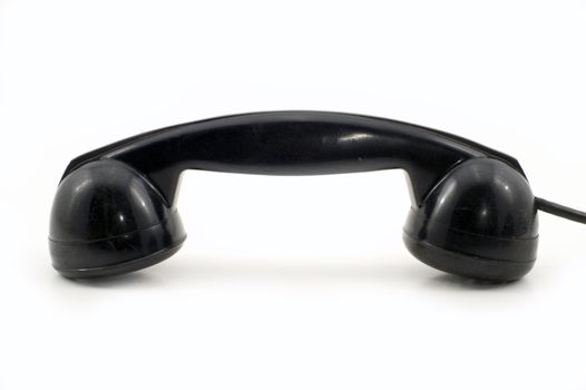 The old telephone of black colour on a white background.