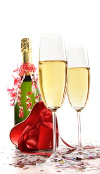 Glasses of champagne with red ribbon heart on white
