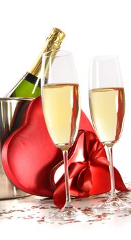 Champagne glasses with valentine gifts on white background