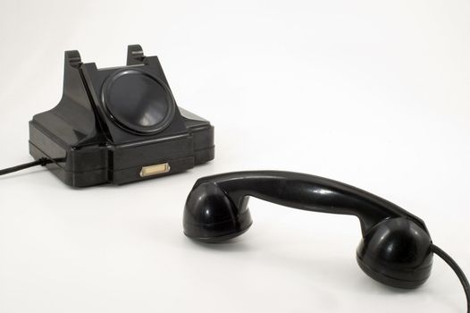 The old telephone of black colour on a white background.