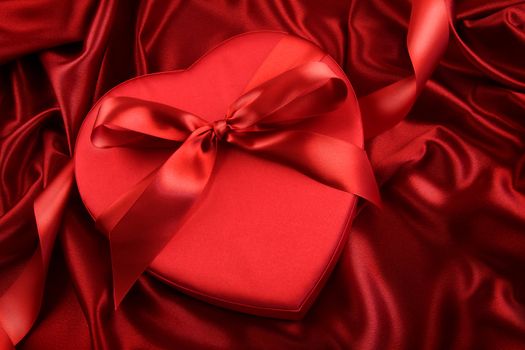 Box of chocolate on red satin background