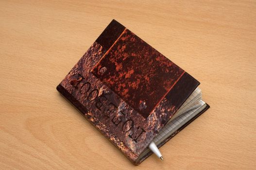 The closed notebook with the handle inside left on a table after record