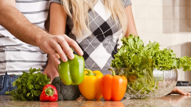 Cropped view of a young couple preparing vegetables on their kitchen counter. Horizontal shot.