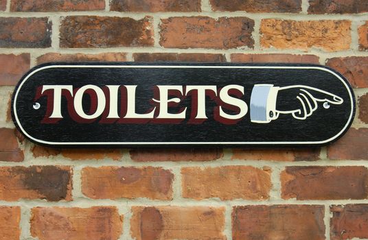 A hand-painted sign, in Victorian style on a red brick background. Clipping path included so the sign can be isolated and placed on any other background.