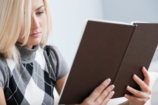 Cropped close-up of woman reading a book. Horizontal format.