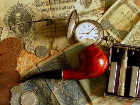 Pipe, old money, old clock and old razor    