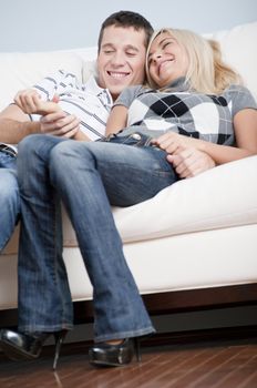 Cropped view of affectionate couple laughing and relaxing together on white couch. Vertical format.