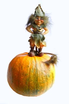 the figurine of gnome standing on a pumpkin 