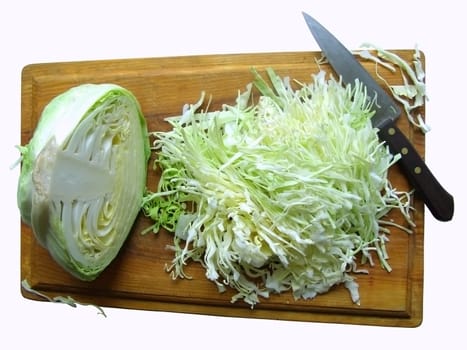 half head of cabbage,knife and choped cabbage on the breadboard    