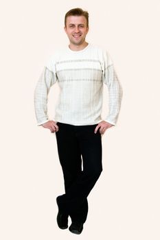 The smiling young man stands. Full-length portrait.