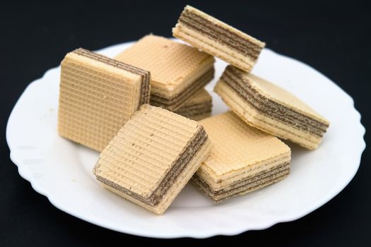 waffles on a white plate on a black background