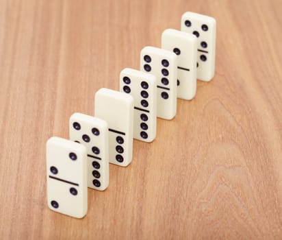 A line from dominoes on a wooden surface