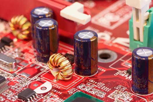 Close up of electronic components on a red circuit surface