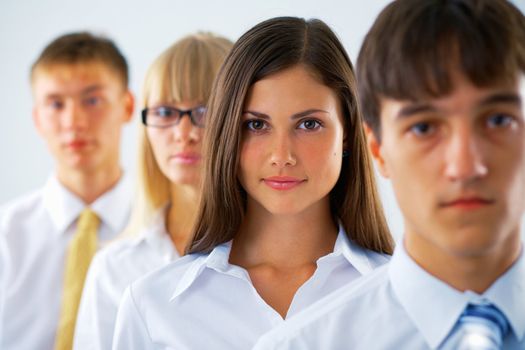 Portrait of young business woman with her colleagues standing in a row