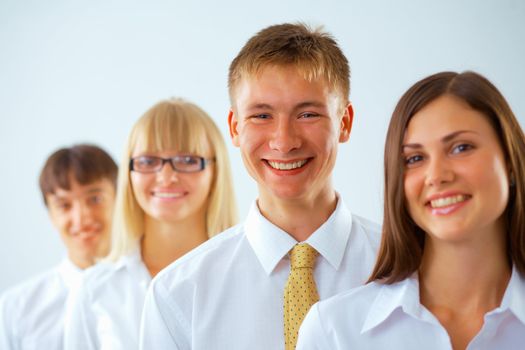 Portrait of young happy business man with his colleagues standing in a row