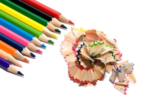 sharpened colored pencils with the chips on a white background