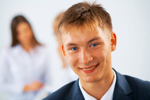 Smiling young business men with women on the background