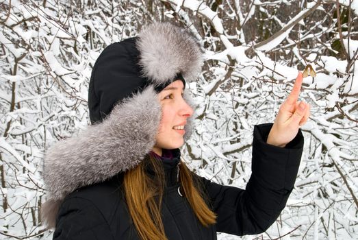 beautiful girl in winter clothing staying in a winter woods