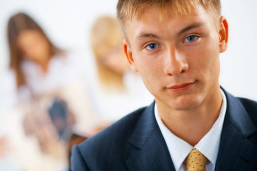 Clouse-up portrait of young serious business man with women on the background