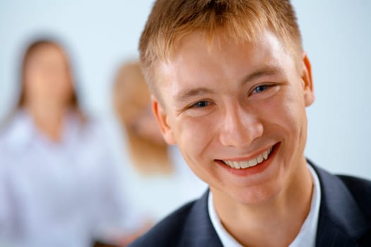 Smiling young business men with women on the background