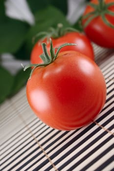 Three tomatoes removed on a striped bamboo napkin