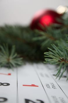 The first of a calendar removed close up against a New Year's ornament