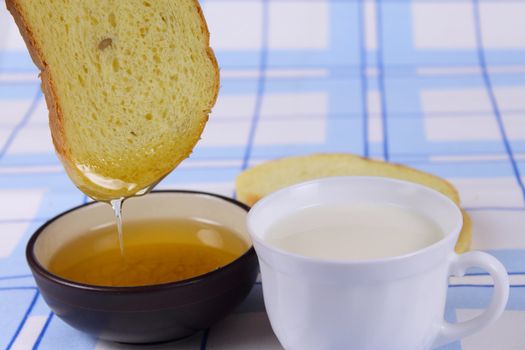Cornbread with honey and milk on a linen blue napkin removed close up