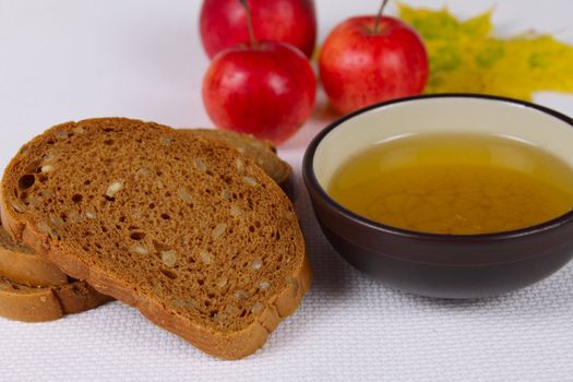 Black bread with honey and apples on a rough linen napkin