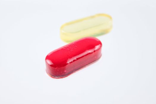 Red and yellow sugar candy removed on a white background close up