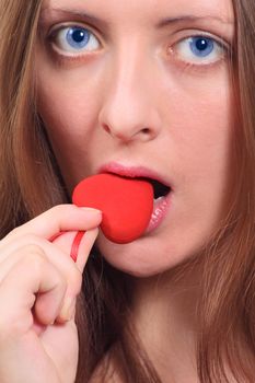 The blue-eyed girl biting plush heart removed close up