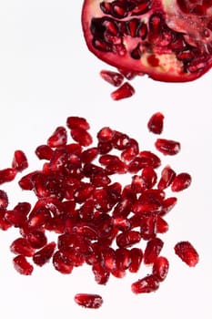 Pomegranate grains removed close up against its part