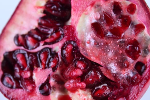 The cut pomegranate with water drops removed close up