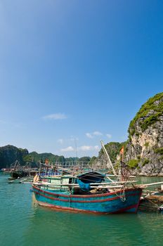 Wooden boat near one of the many fish farms located at Ha Long Bay.