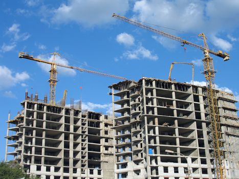 Two elevating cranes of yellow color on a construction site in Volgograd, (look similar images in my portfolio)