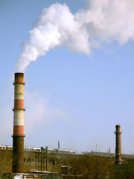 Department of a metallurgical plant with smoking funnels on a background of the blue sky, (look similar images in my portfolio)